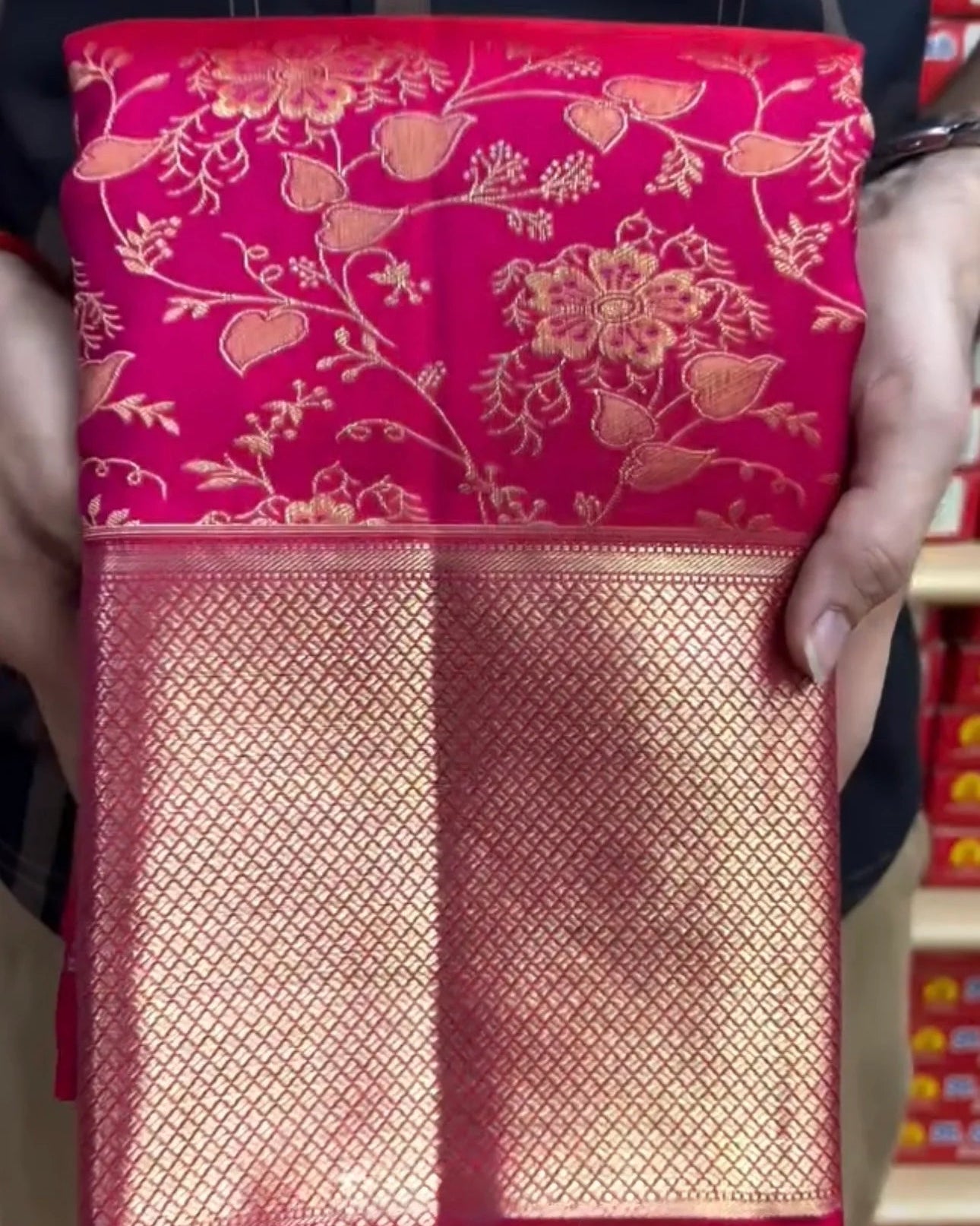 Red floral-patterned fabric held by a person with blurred background
